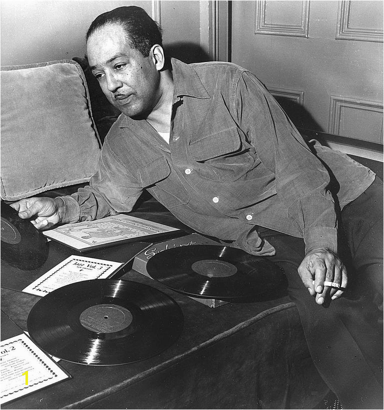 Langston Hughes leaning over records on a couch