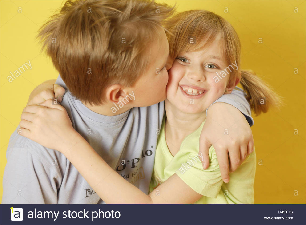 boy girl siblings kiss cheek portrait curled H43TJG