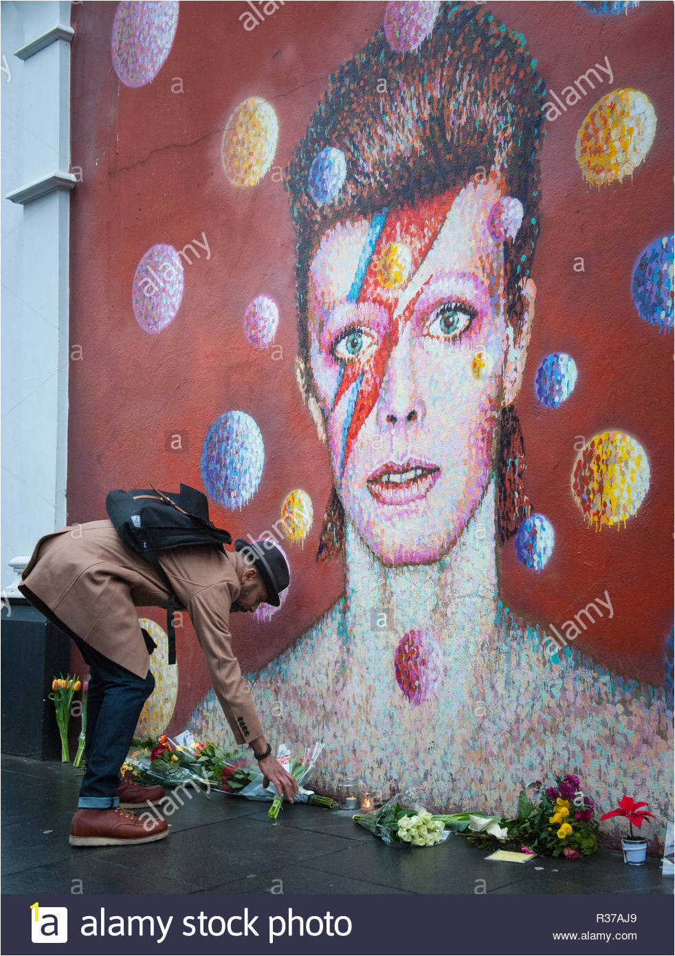 tunstall road london uk 11th january 2016 london uk mourners lay flowers at the foot of the david bowie mural in brixton pictured a man lay R37AJ9