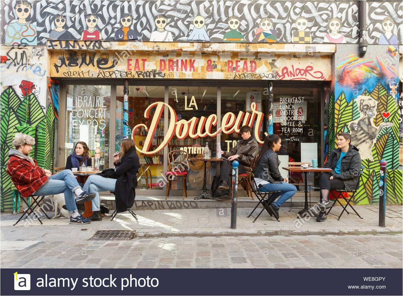 france paris street art graffitis and murals in rue denoyez the terrace of the barbouquin cafe and bookstore WE8GPY