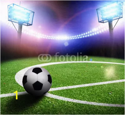 football field with a ball on a stadium with lights and flashes at night webp